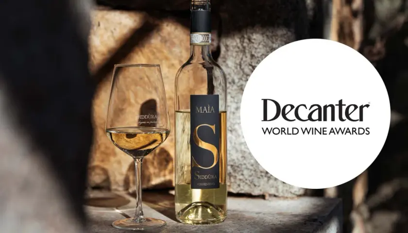 Calice e bottiglia di Vermentino Siddùra Maia, tra i migliori vini bianchi italiani premiati da Decanter World Wine Awards.