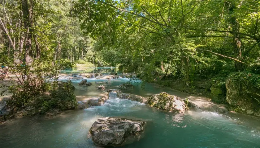 Acque turchesi scorrono tra rocce e vegetazione lussureggiante nel **Val d'Elsa**. Un angolo di paradiso naturale.