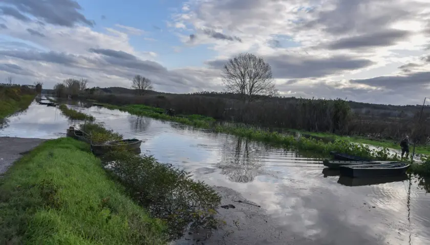 Canale con barche ormeggiate vicino a Ponte Buggianese, riflessi nel cielo nuvoloso.