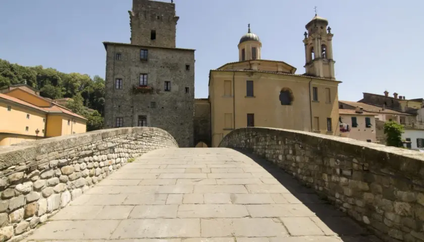 Ponte in pietra a Pontremoli, con torre medievale e campanile. Un luogo incantevole per scoprire cosa fare a Pontremoli.