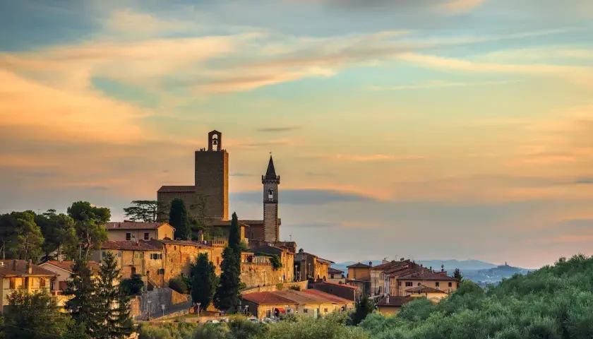Borgo toscano al tramonto, con torri medievali e case in pietra. Un luogo incantevole da scoprire: cosa vedere a Vinci.