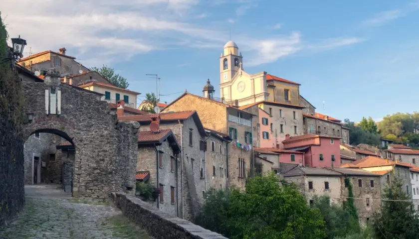 Antico borgo in pietra della Lunigiana, dove si trova un'antica porta d'accesso e una chiesa con campanile.
