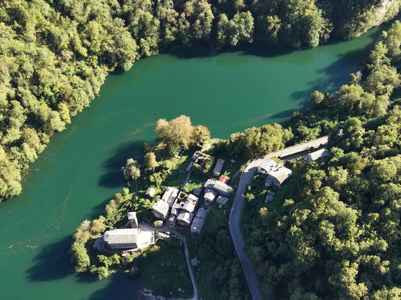 Un borgo incantevole, l'isola santa delle Alpi Apuane, abbracciato da un lago smeraldo e boschi rigogliosi.