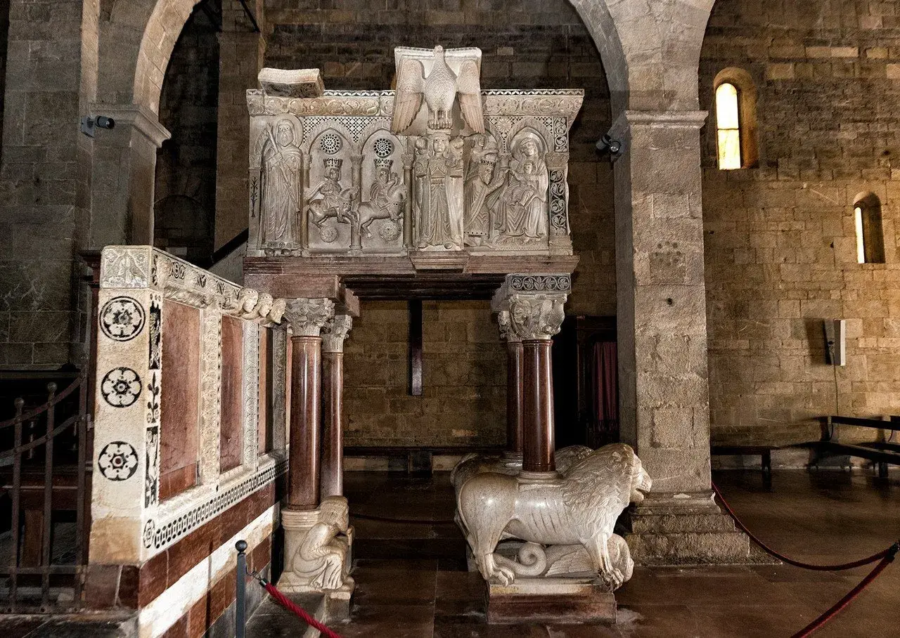 Interno del duomo di Barga con pulpito scolpito e leone stiloforo.