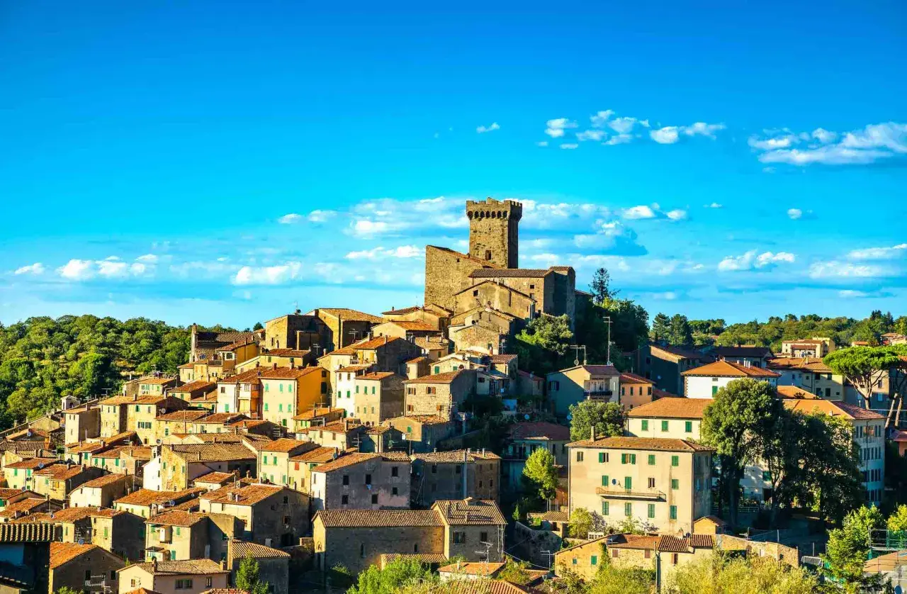 Borgo medievale con torre imponente, un vero gioiello da scoprire. Arcidosso cosa vedere: un panorama mozzafiato tra case in pietra e cielo azzurro.