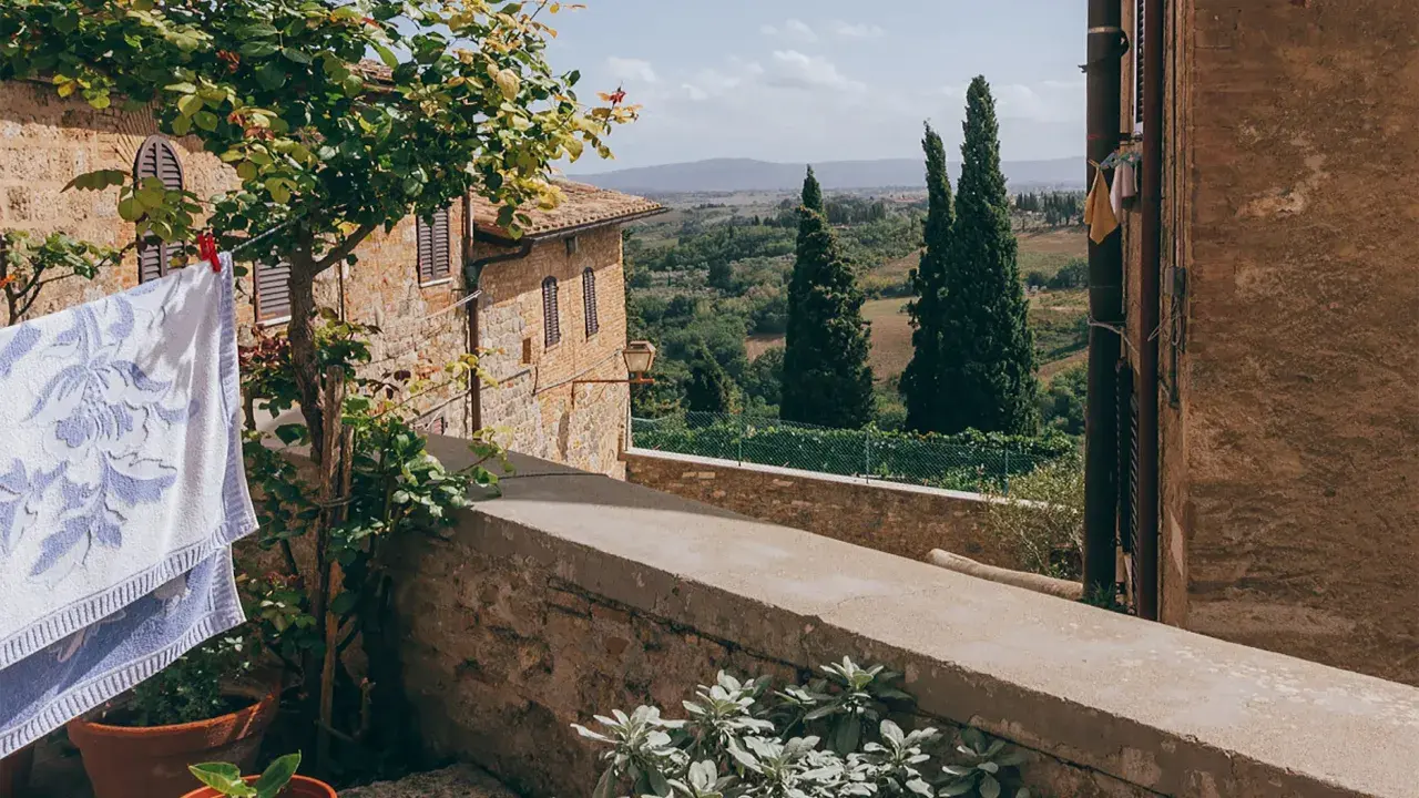 Capalbio, famosa per i suoi borghi medievali e i paesaggi toscani, con panni stesi al sole e cipressi che svettano.