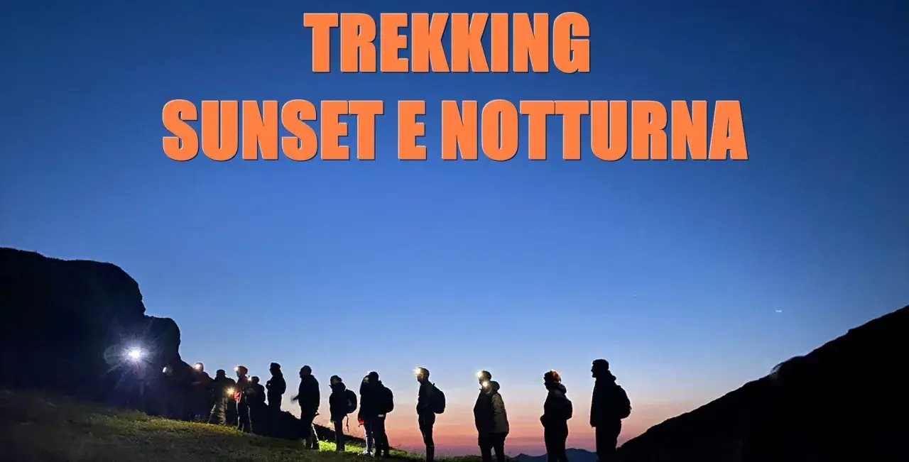 Gruppo di escursionisti al tramonto e di notte al passo dell'Abetone, con luci frontali accese.