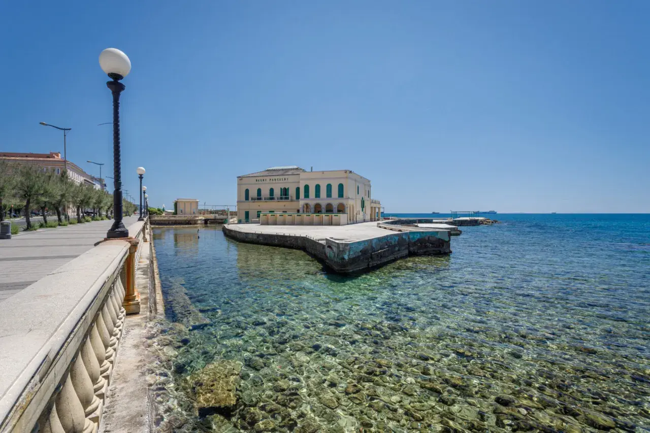 Il lungomare di Livorno con il Bagni Pasquali, un edificio giallo affacciato sul mare cristallino.