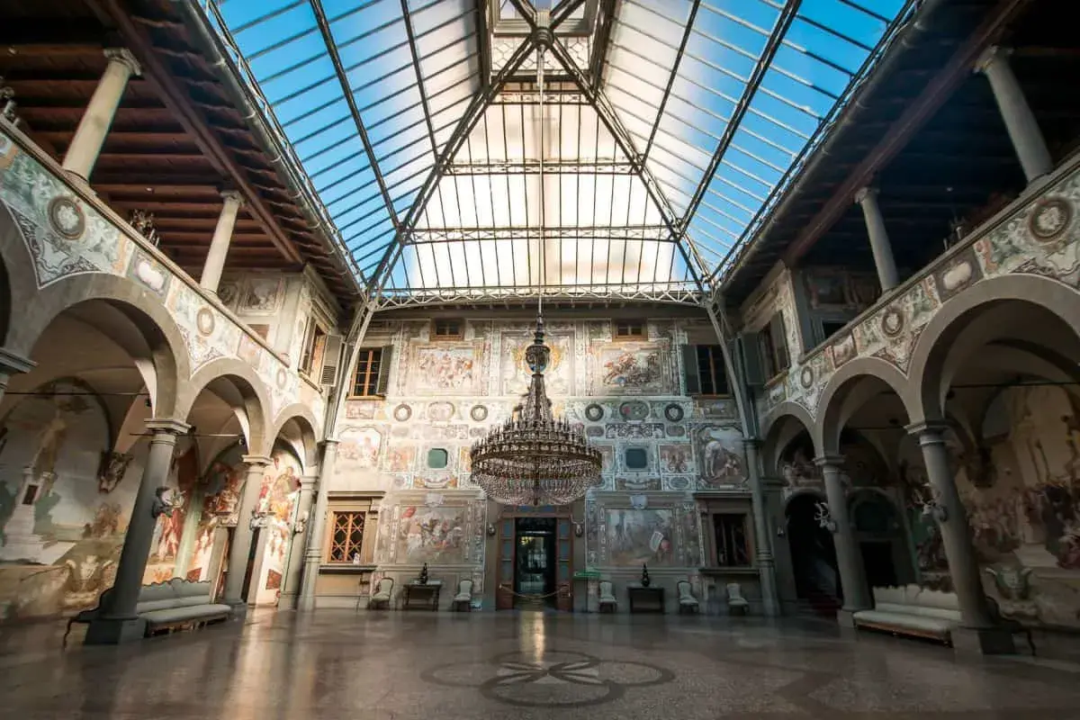 Interno di ville medicee visitabili con affreschi, un grande lampadario e tetto in vetro.