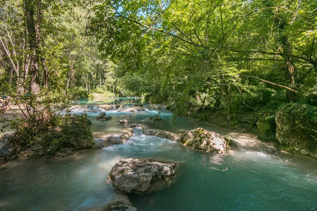 Acque turchesi scorrono tra rocce e vegetazione lussureggiante nel **Val d'Elsa**. Un angolo di paradiso naturale.
