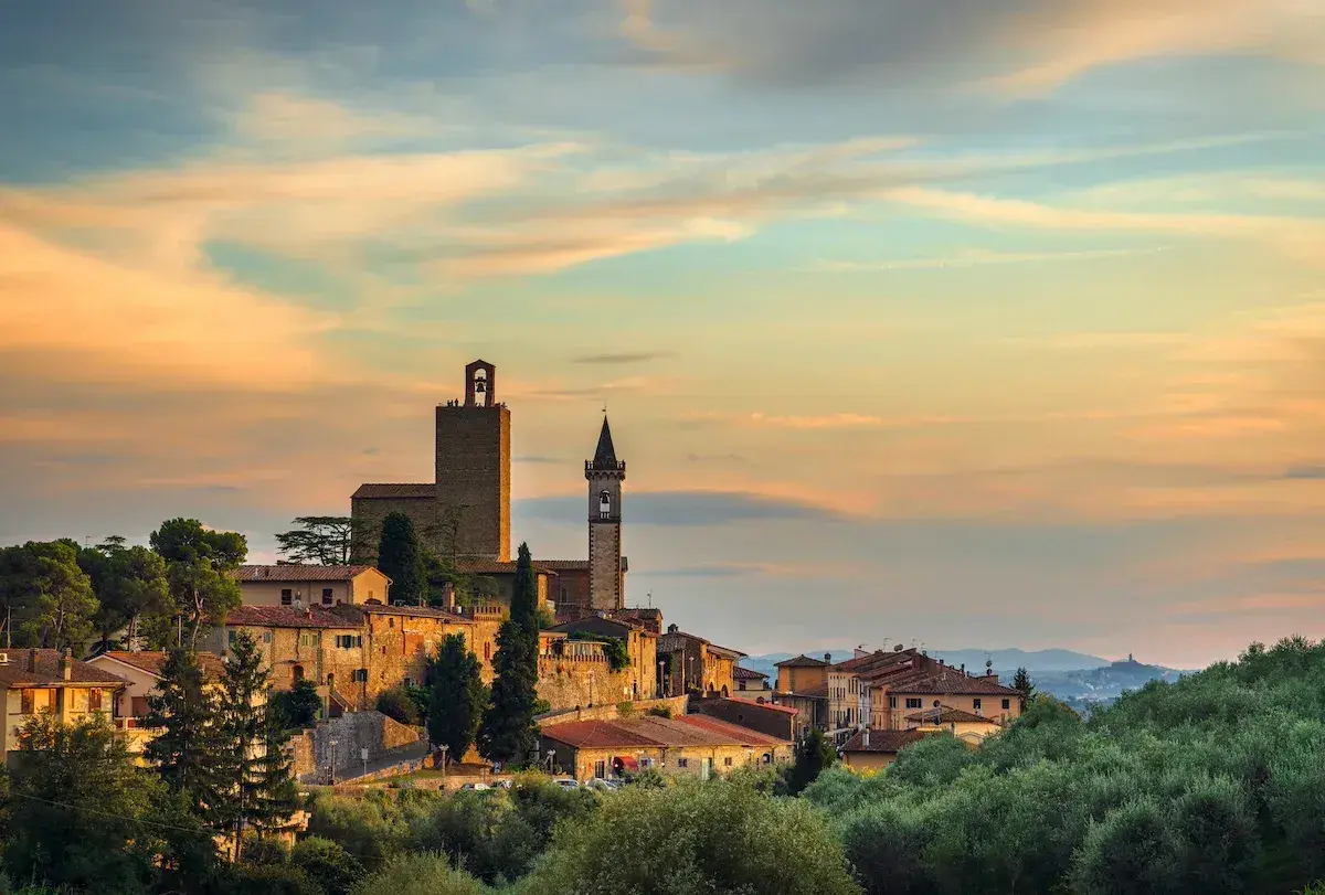 Borgo toscano al tramonto, con torri medievali e case in pietra. Un luogo incantevole da scoprire: cosa vedere a Vinci.