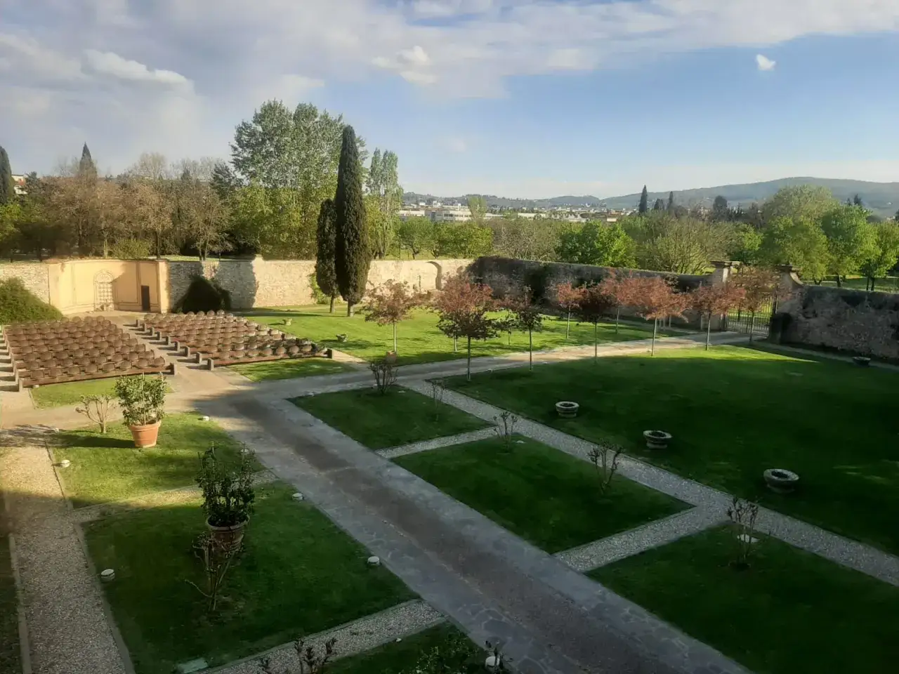 Un anfiteatro all'aperto nel parco dell'Acciaiolo, con file di sedili in terracotta e un prato verde curato.