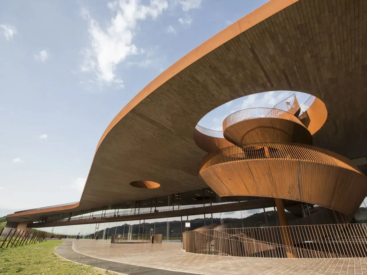 Edificio moderno con scala a chiocciola in corten, parte di una cantina toscana.