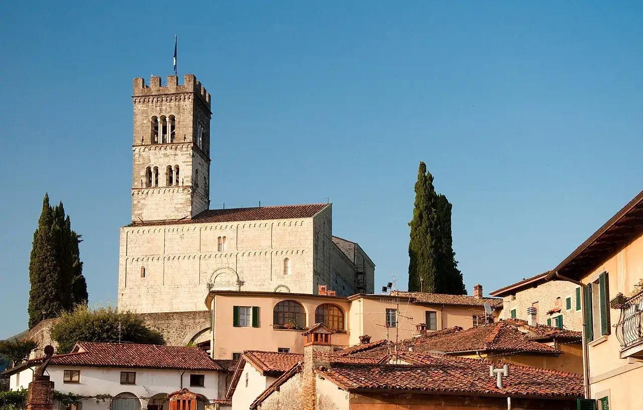Il maestoso duomo di Barga domina il borgo toscano, con la sua torre campanaria che svetta nel cielo azzurro.