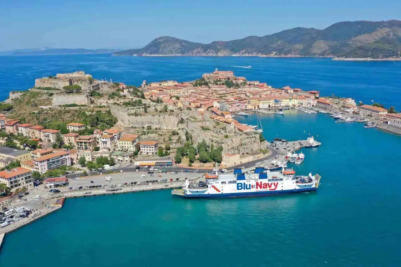 Vista aerea del centro storico dell'Isola d'Elba, con il porto e un traghetto Blue Navy.