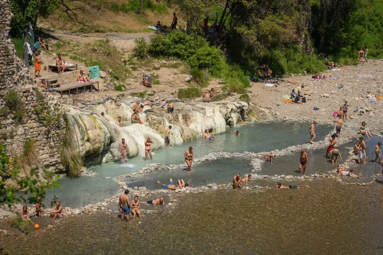 Persone si rilassano nelle acque termali naturali, un'oasi di benessere vicino a Siena.