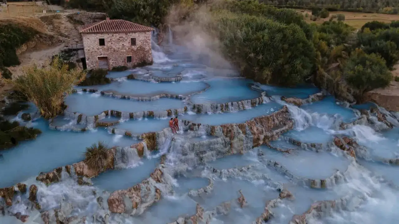 Le Terme di Saturnia, dove si trovano queste cascate naturali di acqua sulfurea azzurra, con un antico mulino sullo sfondo.