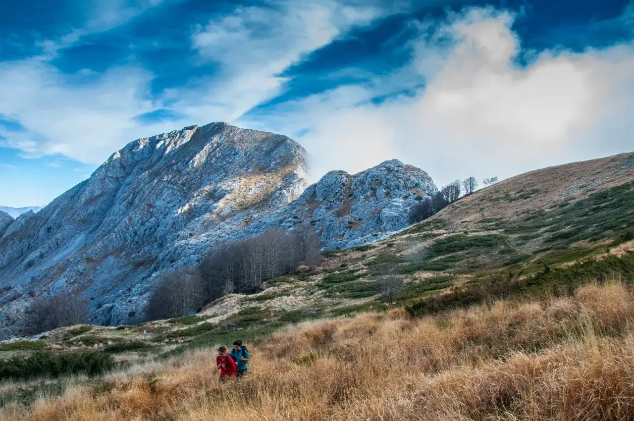 Escursionisti tra l'erba secca e le rocce delle Alpi Apuane. Cosa vedere in questo paesaggio mozzafiato.