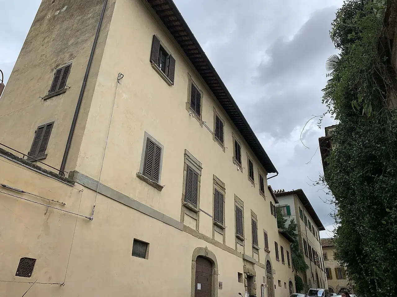 Edifici storici ad Arezzo, con finestre chiuse da persiane scure e un cielo nuvoloso. Un invito a scoprire i musei di Arezzo.