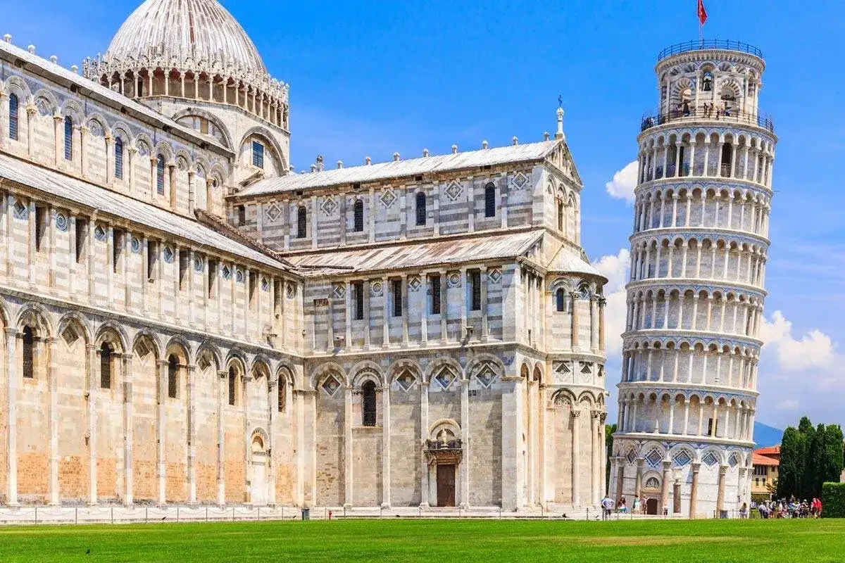 The Leaning Tower of Pisa and the adjacent cathedral under a blue sky.